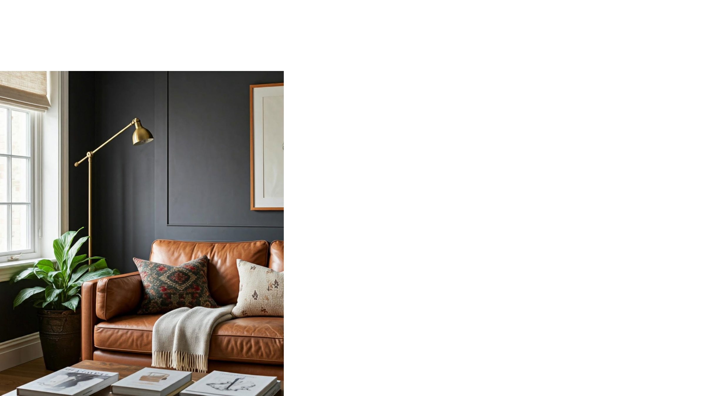 A warm corner lounge with a tan leather sofa, dark walls and layered textures.